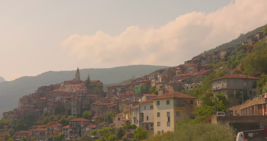 Hillside view of Apricale village with clustered stone houses and mountain backdrop