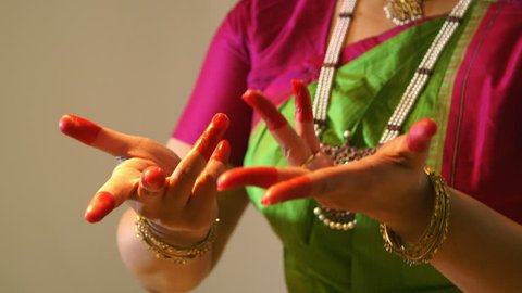 A lovely young woman in traditional dance costume performing classical Indian dance movements. 