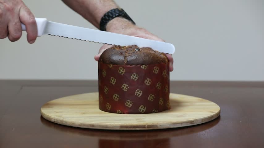 Cutting a traditional Italian artisan panettone with candied fruit.