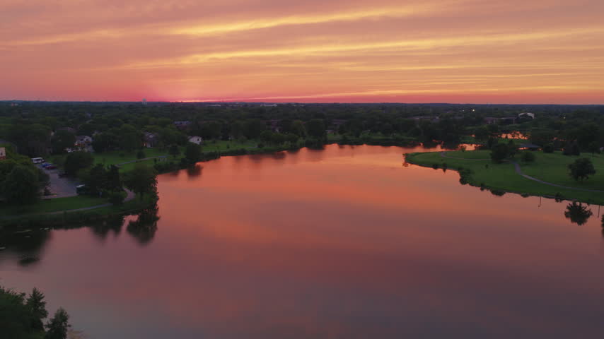 Century Park Big Bear Lake aerial at sunrise, still water and parkland under a glowing dawn sky. Vernon Hills, Lake County, Illinois, USA