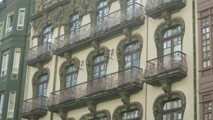 Detail of a beautiful art nouveau building facade with ornate balconies and windows in Gijon