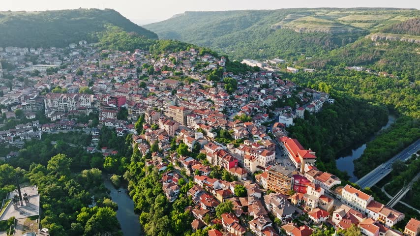 Veliko Tarnovo cityscape aerial view Yantra river bend historic houses hills sunset light Bulgaria medieval capital travel concept
