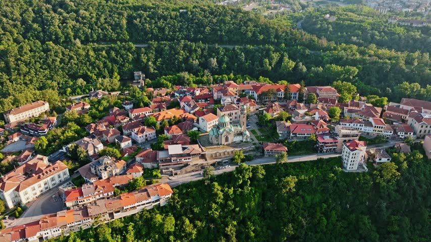 Veliko Tarnovo old town aerial view traditional red roofs architecture green hills summer sunset light Bulgaria travel tourism concept