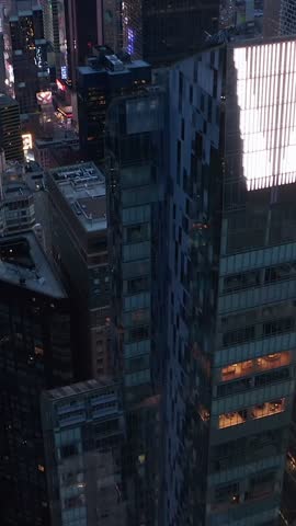 Vertical video: Manhattan Skyline at night with flashing City lights in New York City over Central Park, Aerial forward dolly in