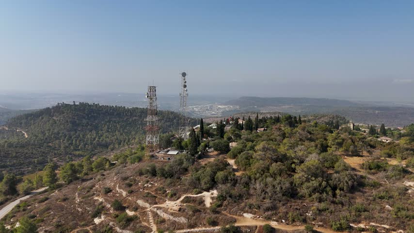 Aerial view of communication towers standing on a forested hill in Beit Meir, Jerusalem District, Israel.