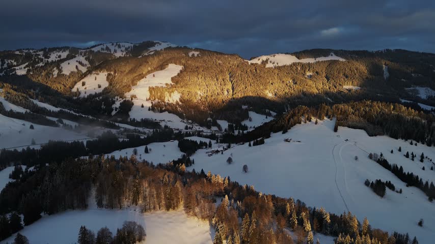 Aerial view of snow-covered mountains during golden hour in Austria.