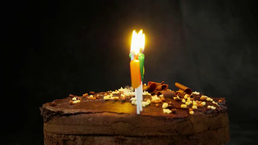 Happy Birthday cake with glowing candles creates a warm and festive celebration scene. Delicious decorated cake, bright candle flames, joyful birthday atmosphere, and traditional party elements make this footage ideal for greetings, celebrations, invitations, and social media content.