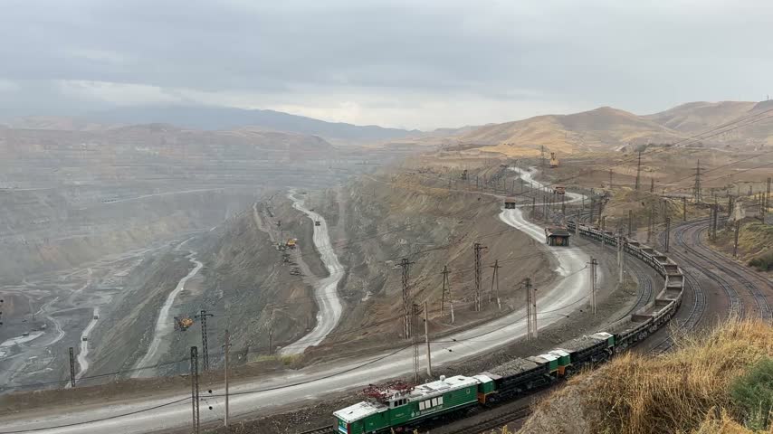 At an open-pit mine in the city of Ormalik, Tashkent Province, Uzbekistan, a freight vehicle loaded with minerals extracted from the bottom of the mine travels along the outer edge of the high mountain (October 2026)