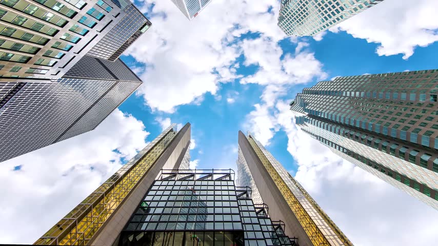 Low-angle wide perspective looking straight up at the gold-coated windows of Royal Bank Plaza and surrounding glass corporate skyscrapers in downtown Toronto, Ontario, Canada, under a partly cloudy blue sky.