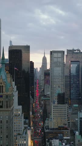 Vertical video: Elevated view of long straight 5th avenue. Commercial high rise buildings against sunset sky. Manhattan, New York City, USA