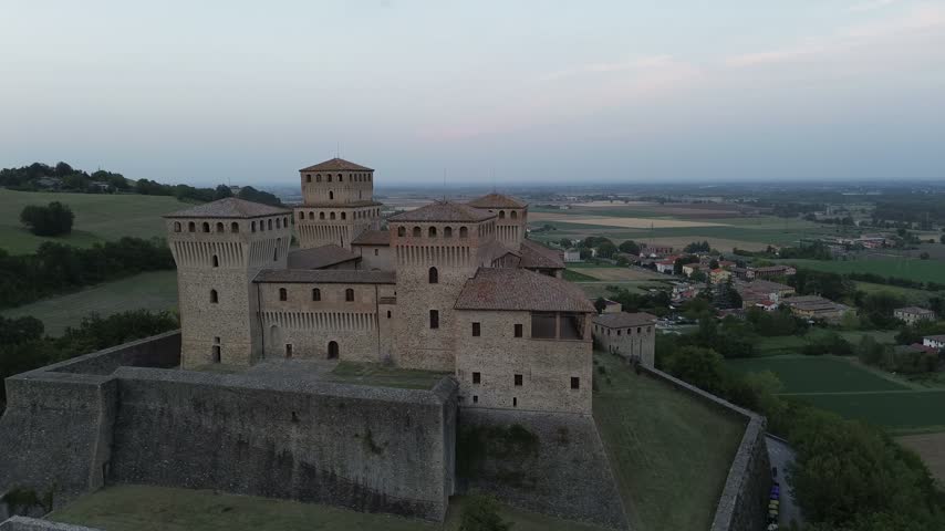Torrechiara Castle aerial view of 15th century Italian fortress at sunset epic monument to power and eternal love story cinematic camera movement Parma region