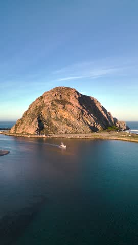 Aerial footage of Morro Rock, Morro Bay at sunrise, California, USA. Morro Rock is a granite dome rock formation in Sequoia National Park, California, United States.