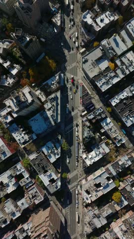 Vertical aerial view showcasing Manhattan streets in slow motion in New York City, featuring yellow cabs. Urban landscape highlights city