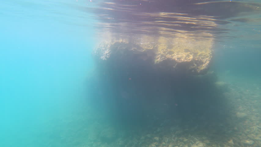 View underwater rock formations and marine life in clear blue water during exploration in the Mediterranean.