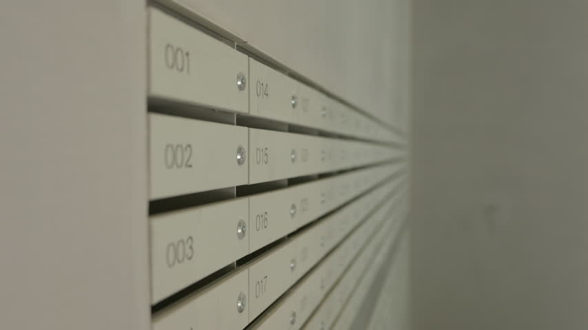 Numbered metal mailboxes installed in modern apartment building