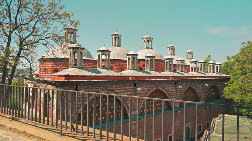 Historic Ottoman brick building with arched windows and rooftop chimneys in Istanbul, Turkey