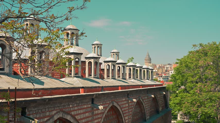 Historic Ottoman brick building with arched windows and rooftop chimneys in Istanbul, Turkey