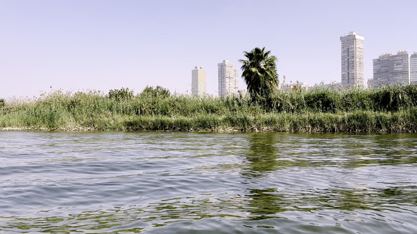 Felucca ride on the River Nile in Cairo, Egypt, filmed from on board the traditional sailing boat, calm water and city riverbank