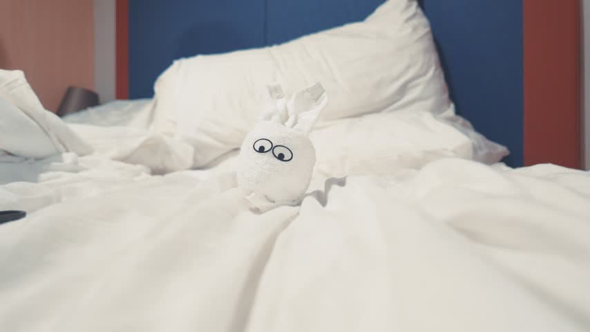 Cute White Towel Animal Shaped Like a Rabbit on Hotel Bed