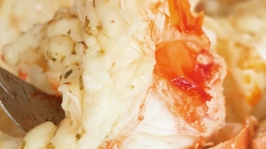 A macro, slow-motion shot focusing on a freshly prepared, succulent lobster tail.