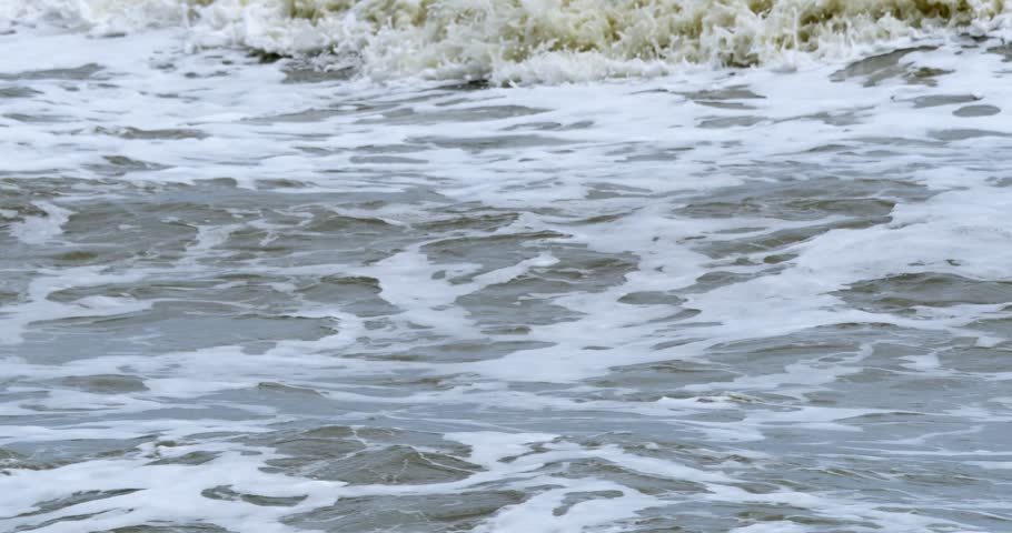 Scene of turbulent ocean waves crashing dramatically against shoreline.