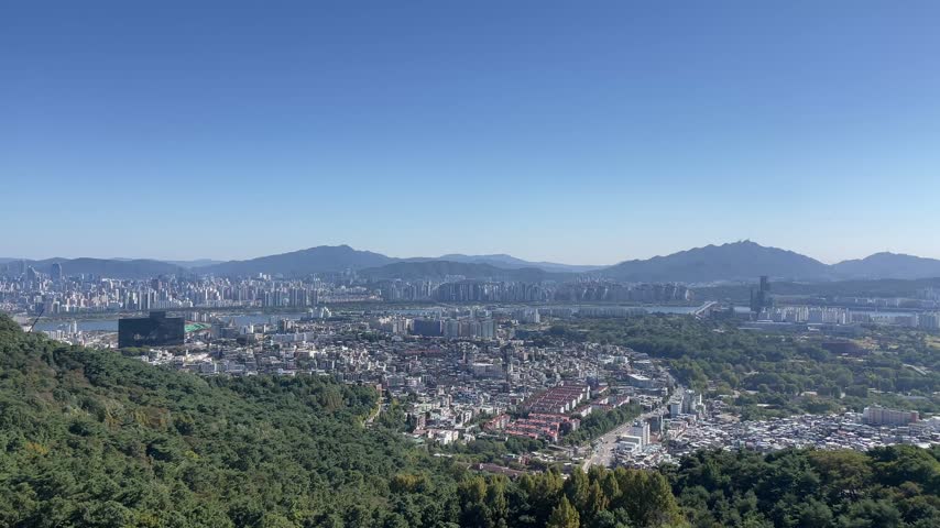 Panoramic view of Seoul from Namsan Mountain near N Seoul Tower, showing the surrounding mountains and urban landscape of South Korea 
