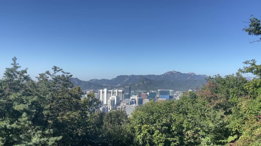 Panoramic view of Seoul from Namsan Mountain near N Seoul Tower, showing the surrounding mountains and urban landscape of South Korea 