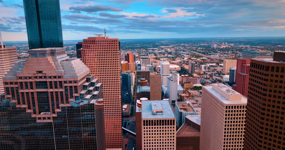 Footage at the tops of the high-rises from drone. Panorama of beautiful Houston, Texas, USA at sunset.