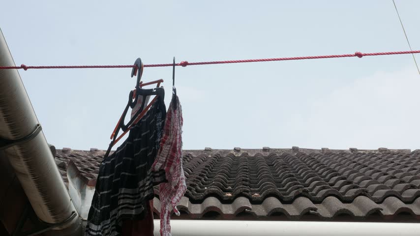 Clothes Hanging on a Clothesline to Dry Outdoors Under the Sun