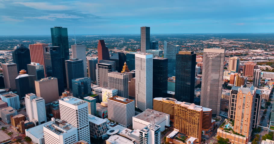 Cluster of high-rise buildings in the modern downtown of Houston, Texas, USA. Low-rise green scenery of uptown at backdrop.