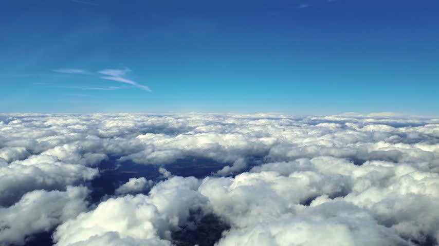 Immersive pilot eye view from a jet cockpit in a flight at supersonic speed flight through a layer of fluffy cumulus clouds in the dencent. 4K