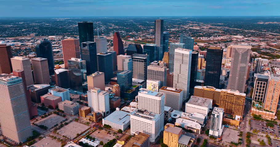 Complex of diverse high-rises in Houston downtown, Texas, USA. Green low-rise scenery of uptown at backdrop.