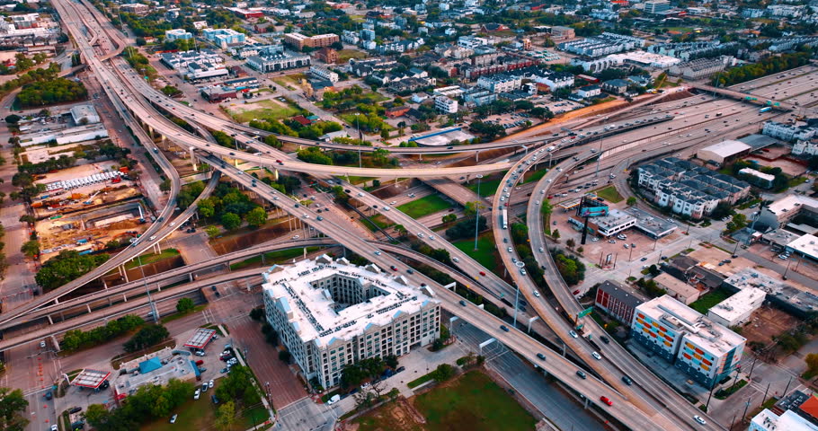 American interchange and highways junction with hectic traffic at daytime. Numerous cars run by the roads in Houston downtown, Texas, USA.