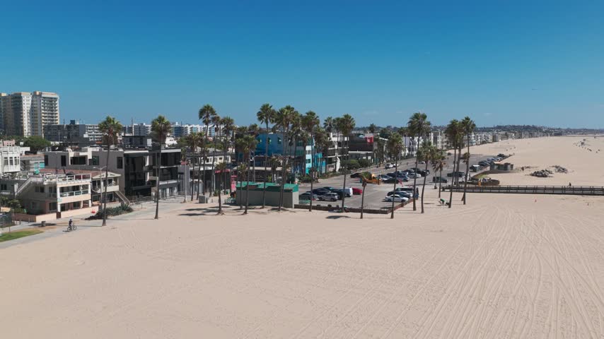 Wide panning shot of the Venice Beach parking lot on a warm summer day in Los Angeles, California. 4K