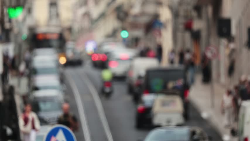 Iconic yellow tram passing through a blurred city street in lisbon