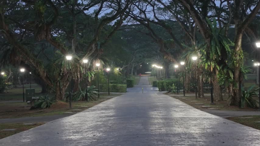 A peaceful landscape showcasing a scenic public park alongside a sandy beach and a flowing river under hazy skies.