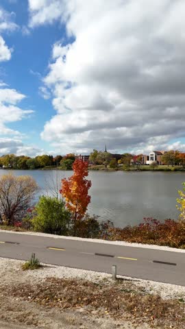 Slow Approach towards Fox River in De Pere Wisconsin.  Fall Colors surround the water with picturesqe Clouds overhead
