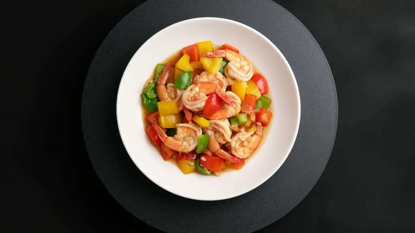 Stir-Fried shrimp with Bell Pepper and Black peppercorns in white plate. Top view.