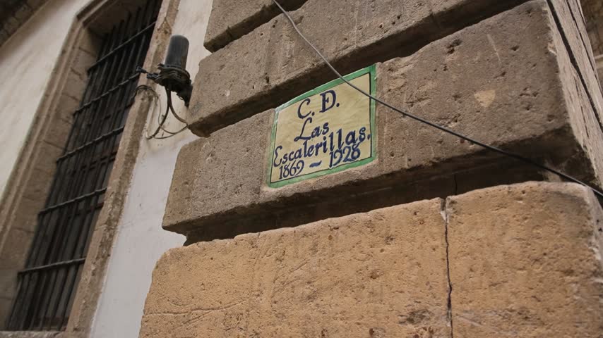 A plaque reading C D Las Escalerillas 1869 1928 mounted on an old stone facade in Mexico City