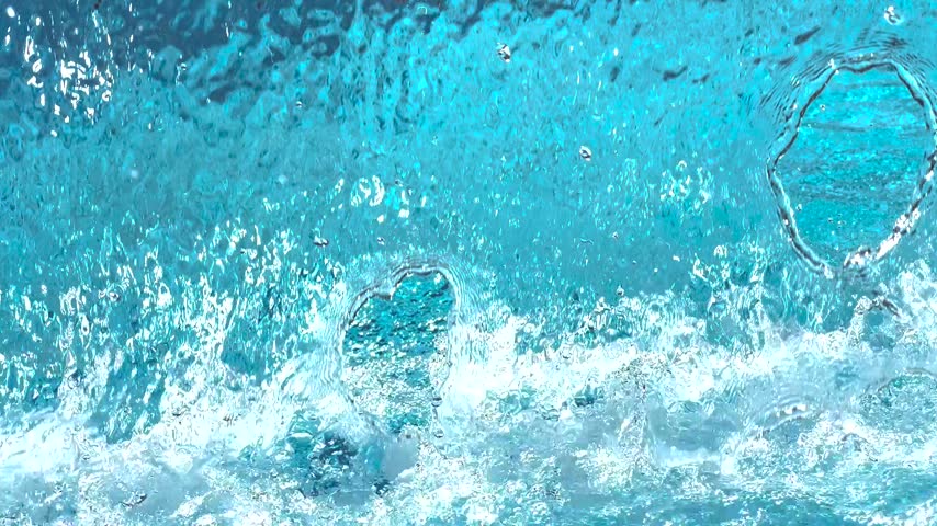 Pure blue water splashing in a pool with bubbles creating a refreshing and dynamic background