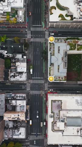 Vertical video: Aerial views showcase a yellow cab maneuvering through a busy New York City intersection, highlighting the lively urban scene and bustling traffic of this iconic city