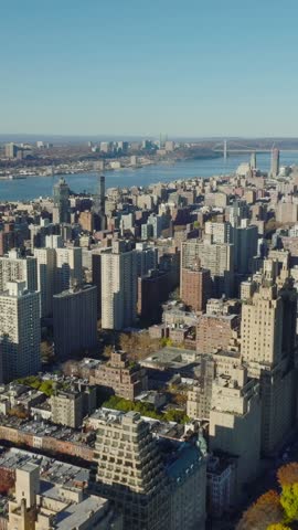 Vertical video: Sunny day in residential borough. Aerial view of buildings near autumn Central Park. Manhattan, New York City, USA