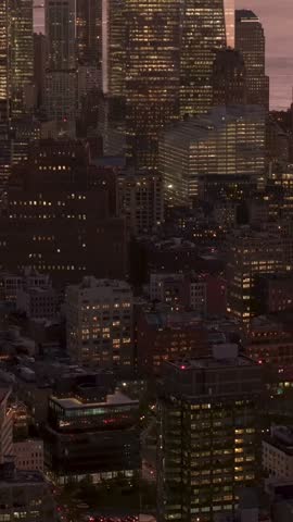 Vertical video: Sunset golden light bathing New York City skyline, highlighting One World Trade Center and surrounding skyscrapers of Lower Manhattan in warm, vibrant hues