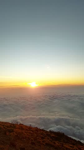 JUDUL:
Sunrise Over Endless Sea of Clouds From Mountain Peak

DESKRIPSI:
Golden sunrise rising above a thick and beautiful sea of clouds viewed from a high mountain summit in Central Java Indonesia Peaceful morning landscape with warm sunlight
