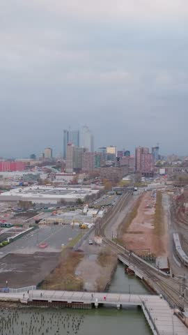 Vertical video: Urban landscape capturing Hoboken and Jersey City soaring skyline with sweeping view of complex railway infrastructure spanning New Jersey aerial panorama