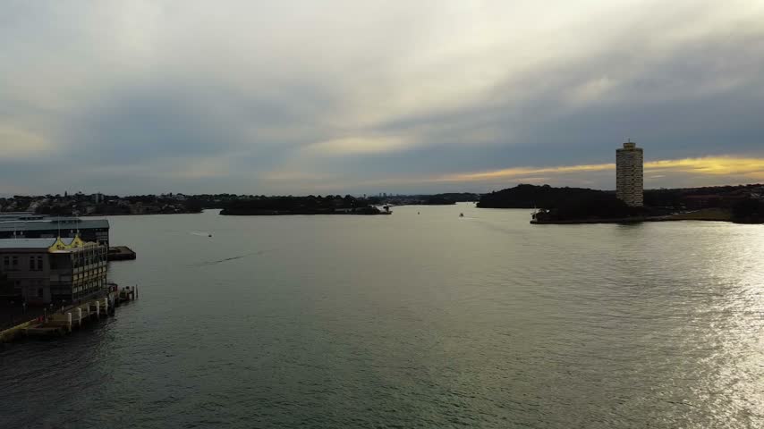 Panoramic view of walsh bay and sydney harbour at sunset. Moving clouds over the calm water with boats and the city skyline in the background