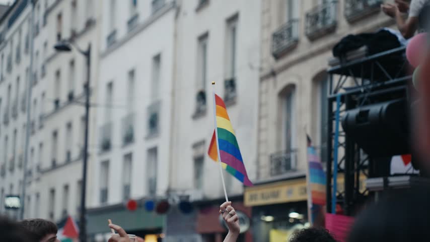Waving rainbow flag at an outdoor lgbtq pride parade celebrating equality, diversity and freedom