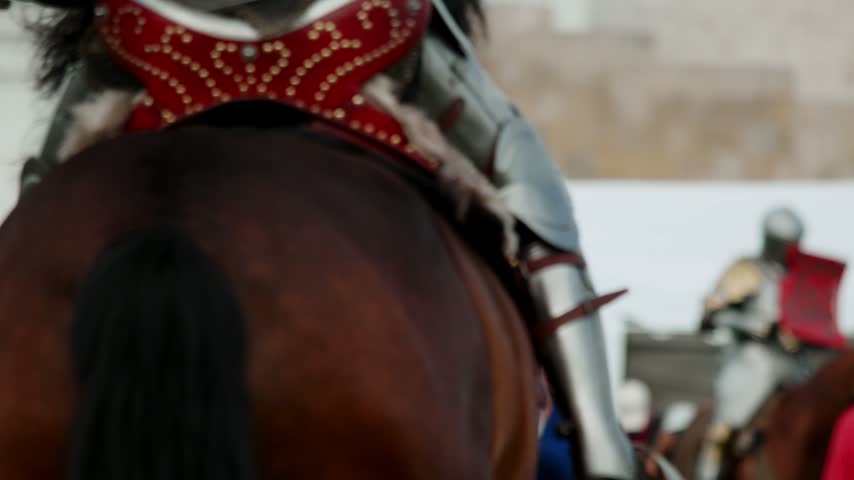 Slow motion shows knight breaking wooden lance against enemy shield. Mounted warrior wins spectacular jousting clash during historical medieval combat reconstruction festival