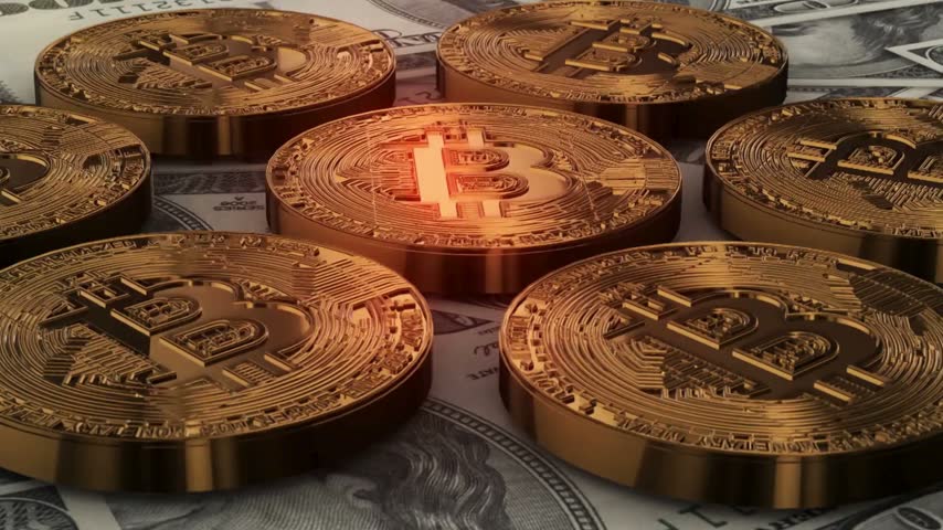 Gold Bitcoin Cryptocurrency Coins Rotating on US Dollar Bills Background