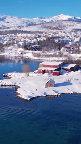 Experience the breathtaking beauty of Tromso, Norway during winter. Discover the serene beaches, icy waters, and snow-capped mountains and fishing village.